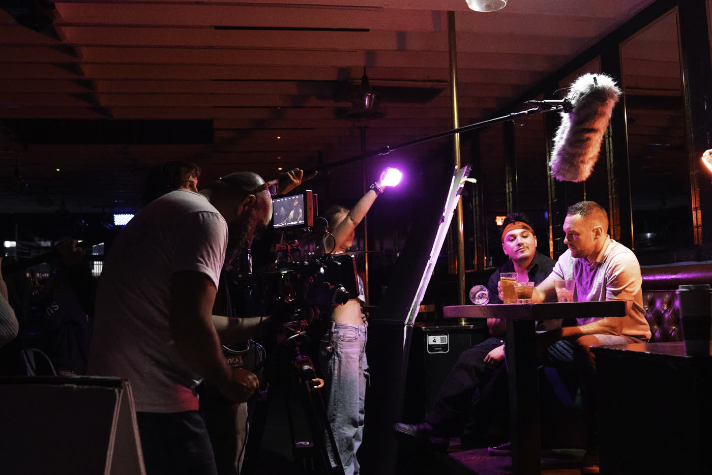Crew filming a table scene under purple light on Fair Trade