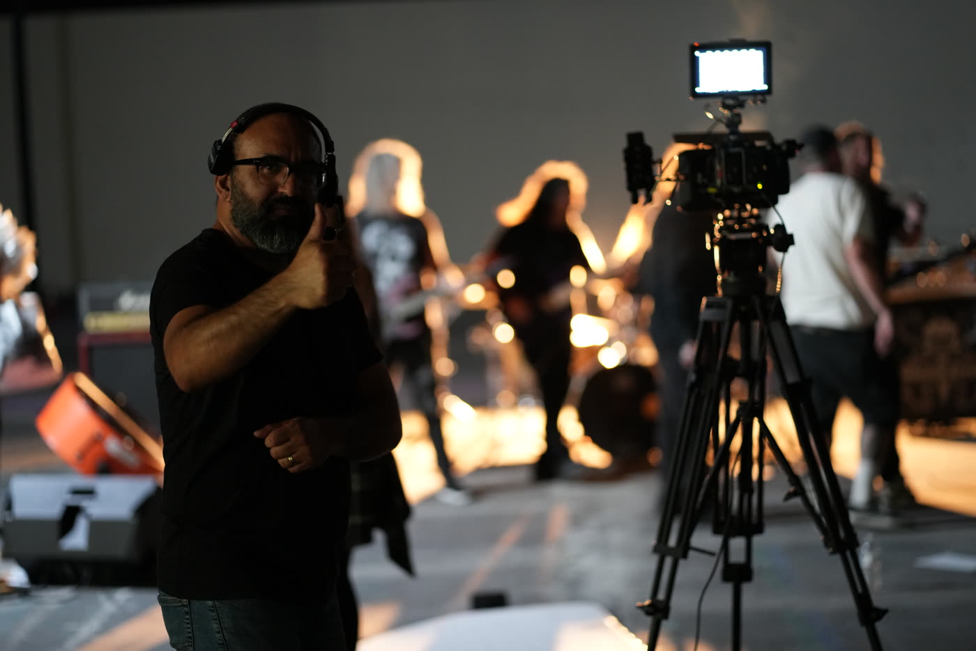 Oz Riveros directing beside the camera on a warehouse music video set
