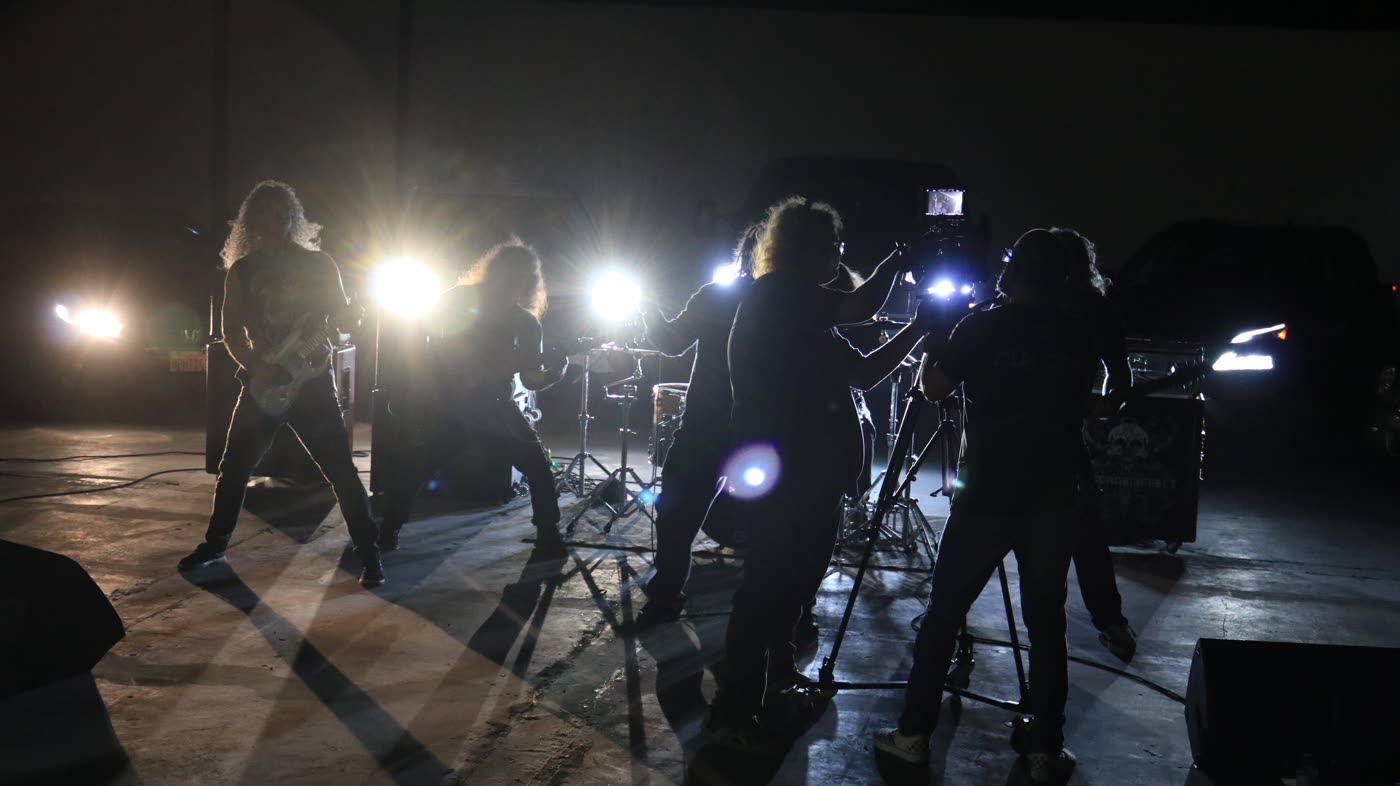 Backlit band and crew mid-take in a warehouse