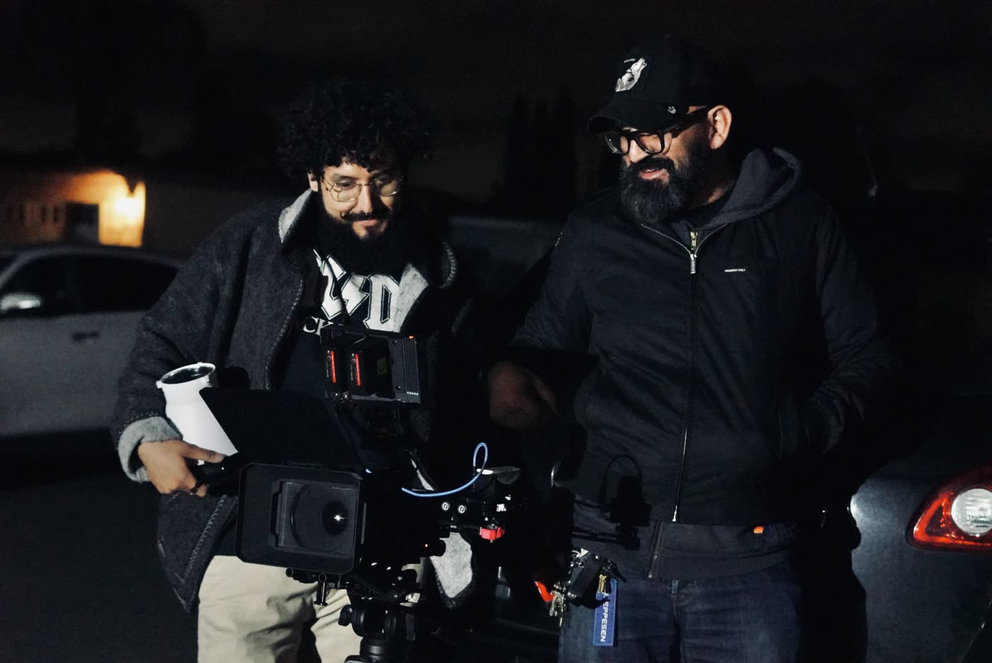 Two crew members with the camera rig outside at night