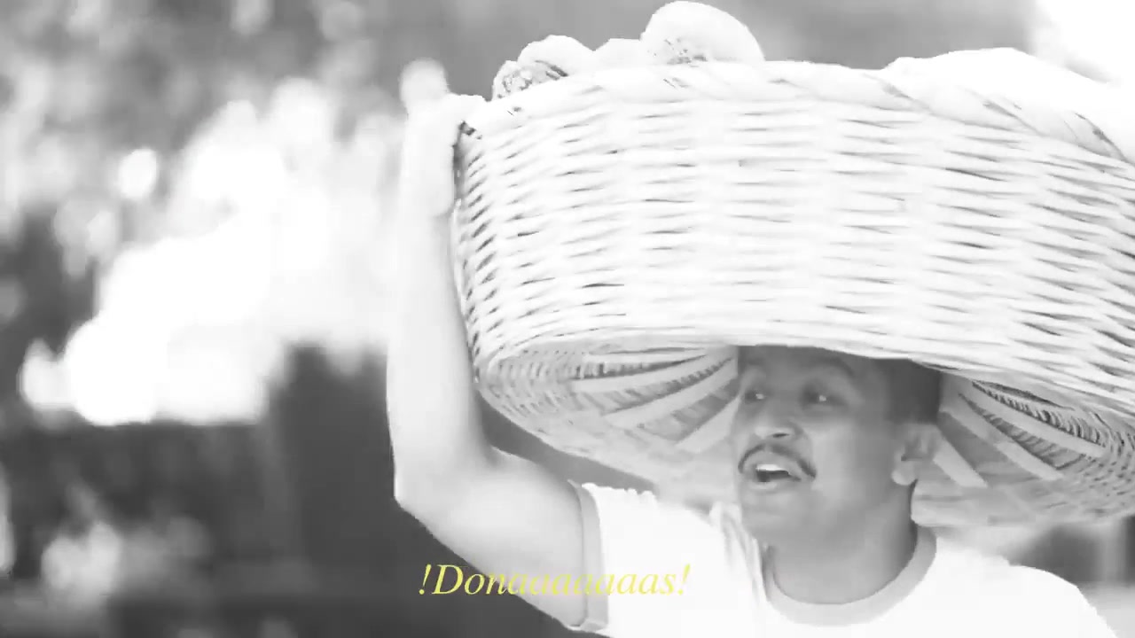 Barrio Donas: El Panadero calling out ¡Donas! with a basket of donas on his head